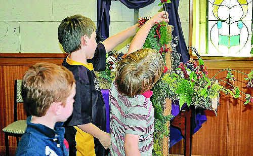 Members of the congregation put flowers on the cross at the end of the Easter Sunday service at the Uniting Church. Members of the congregation put flowers on the cross at the end of the Easter Sunday service at the Uniting Church.
